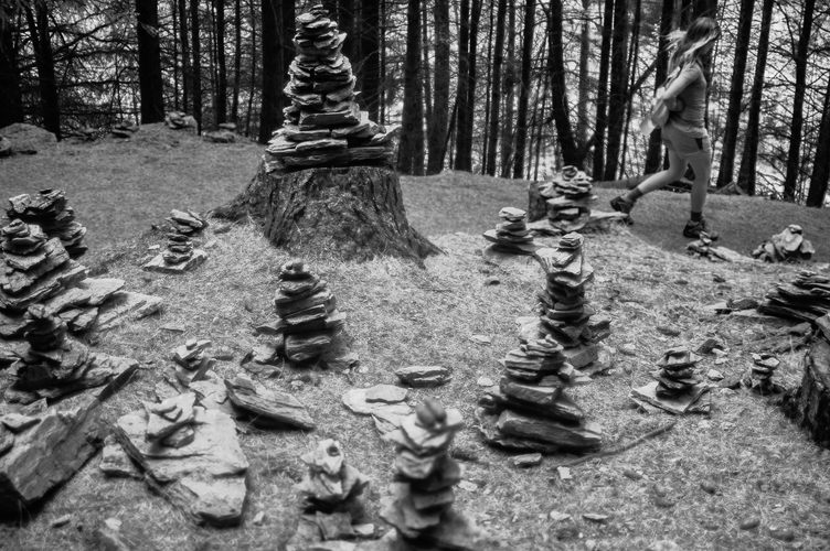 Piles of stacked rocks, Britt walking briskly.